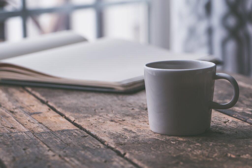 Une table dans un café littéraire, une tasse bien pleine, un stylo et du papier, et un manuscrit est né !